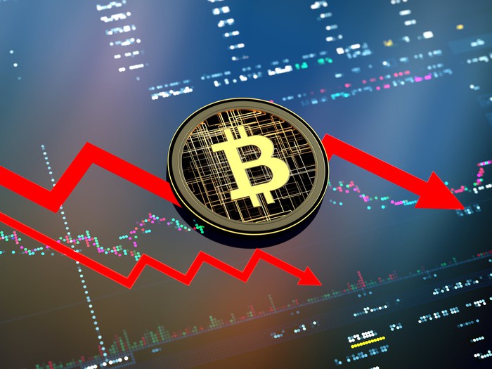 Round Bitcoin symbol overlaid on a falling stock chart